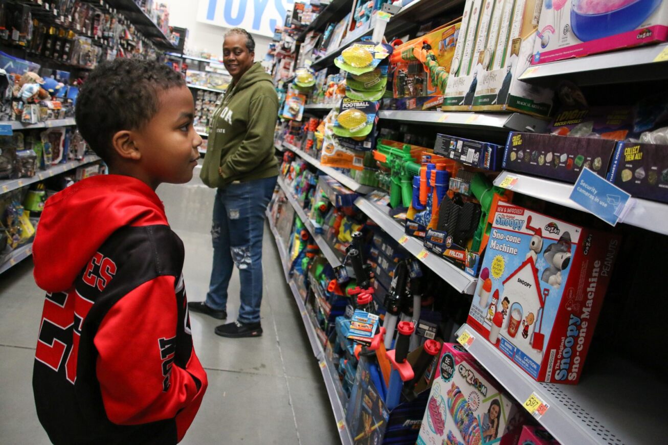 A boy browses the toy aisle to pick out something for himself.