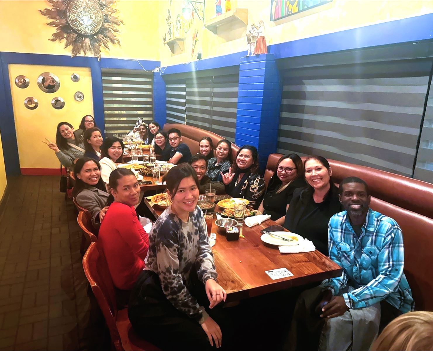 The new Exceptional Ed international teachers smile at a restaurant table.