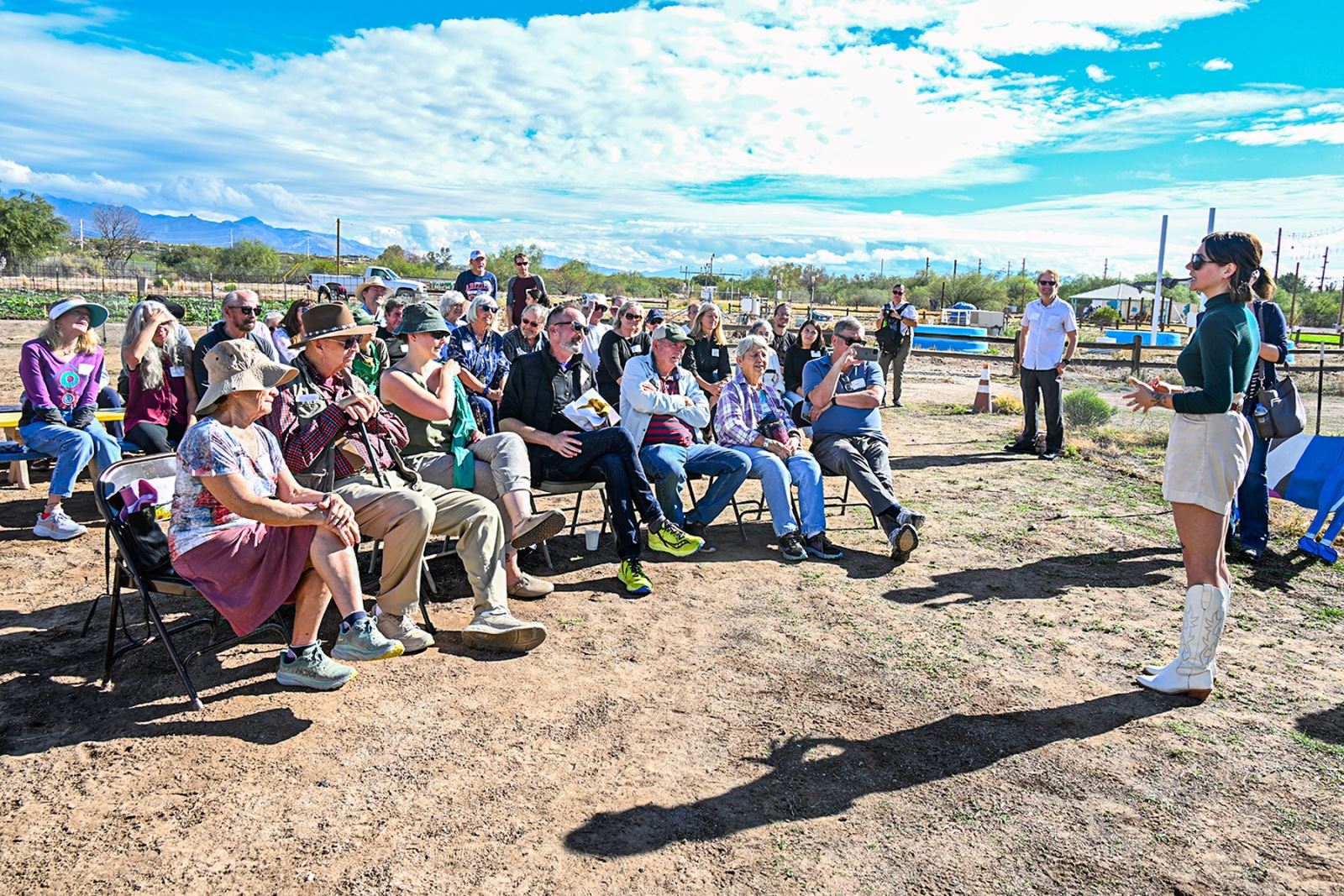 A group of people listens to an award presentation for John Brooks at Ƶapp Village Farm.